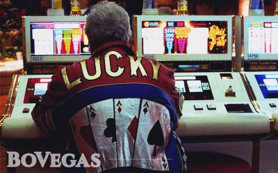 Gambler in Lucky Shirt sits and play slots 